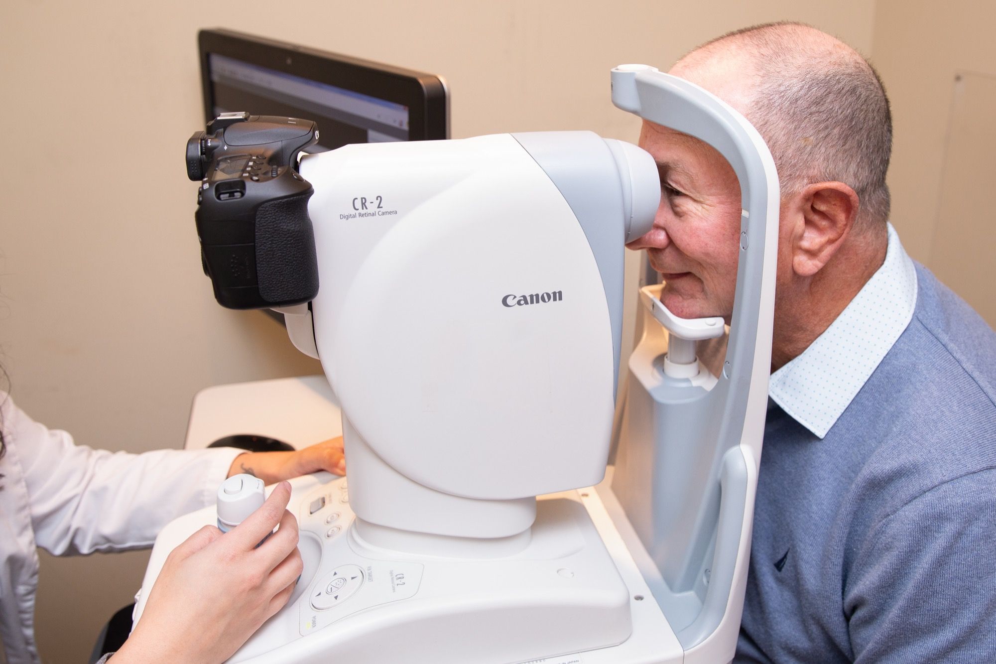 A patient at a retinal camera during an eye health exam